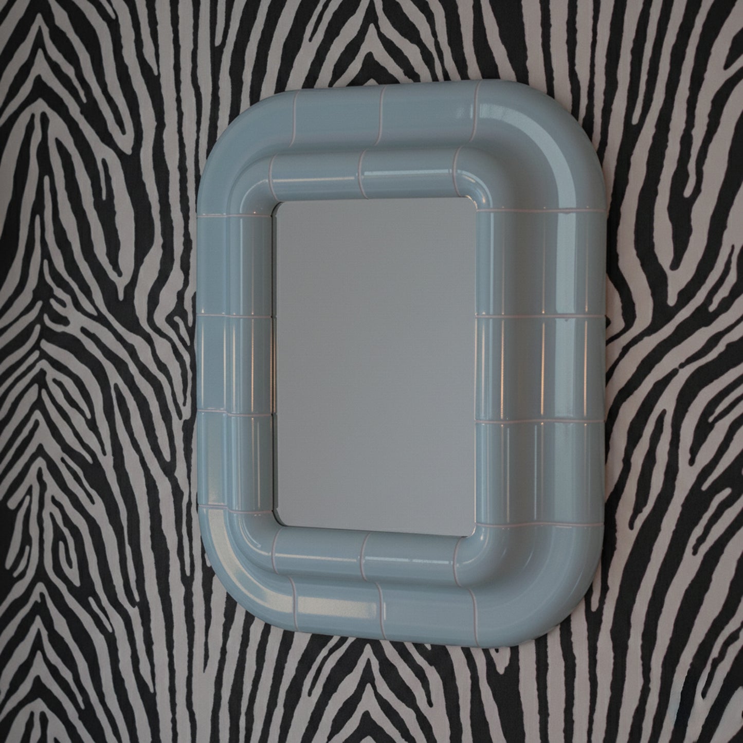 Ice Blue ceramic-look mirror shown in angled perspective, highlighting rounded edges and glossy finish.