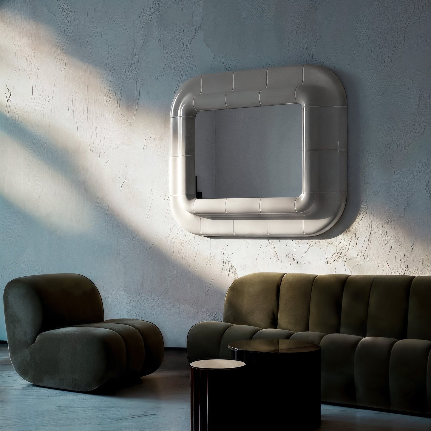 Wall-mounted square mirror with rounded corners and smooth glossy surface, interacting with light and shadow in a minimalist interior.