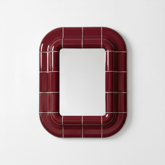 Ceramic-look mirror with rounded square shape in deep burgundy, glossy finish, shown front-facing on a light neutral background.