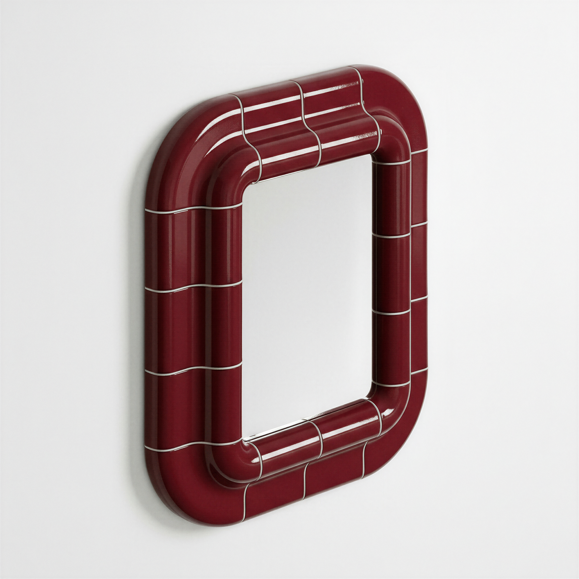 Deep burgundy ceramic-inspired mirror mounted on wall, shown in angled perspective highlighting its curved frame and glossy surface.