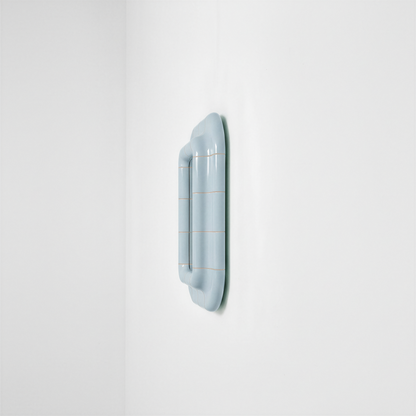 Side view of the Ice Blue ceramic-look mirror showing frame depth and curved profile.