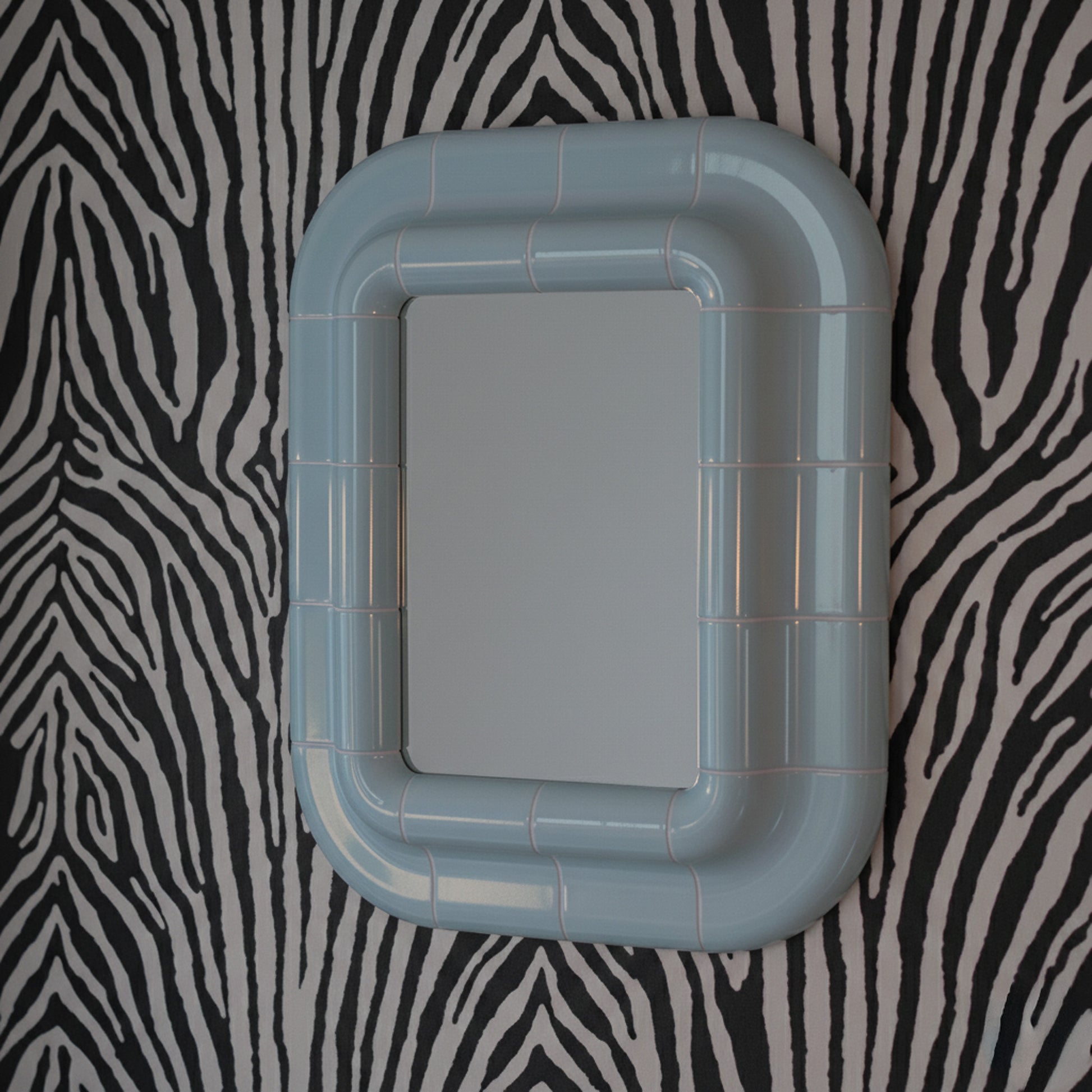 Ice Blue ceramic-look mirror shown in angled perspective, highlighting rounded edges and glossy finish.