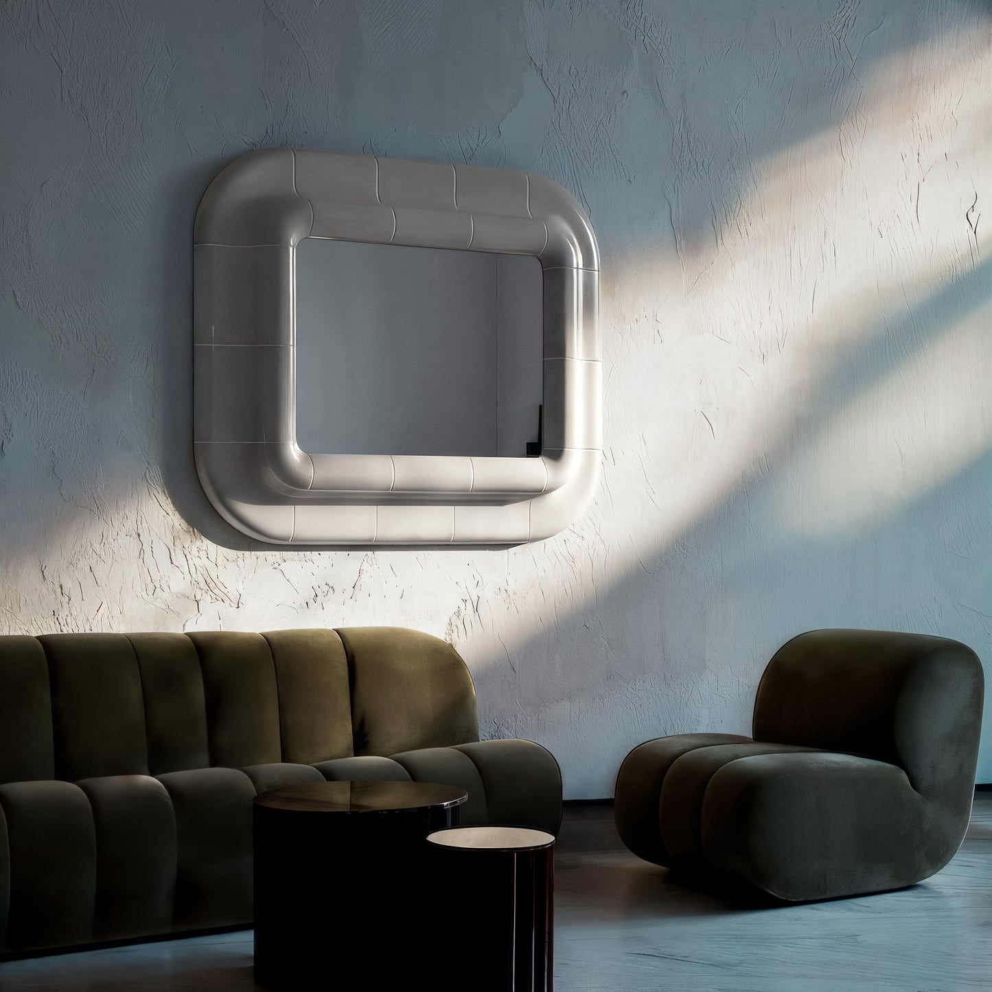 Wall-mounted square mirror with rounded corners and smooth glossy surface, interacting with light and shadow in a minimalist interior.