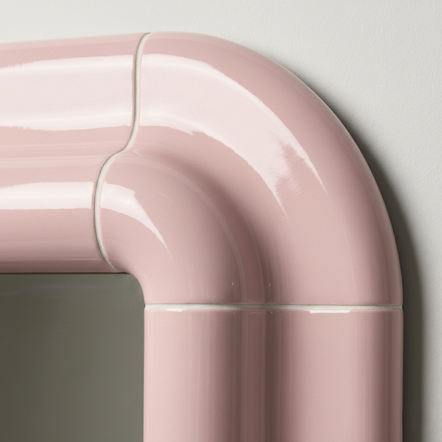 Detail of Lolo mirror in Blush Pink by Tilecito, rounded corner with high-gloss tile-inspired surface and visible grout-style lines.
