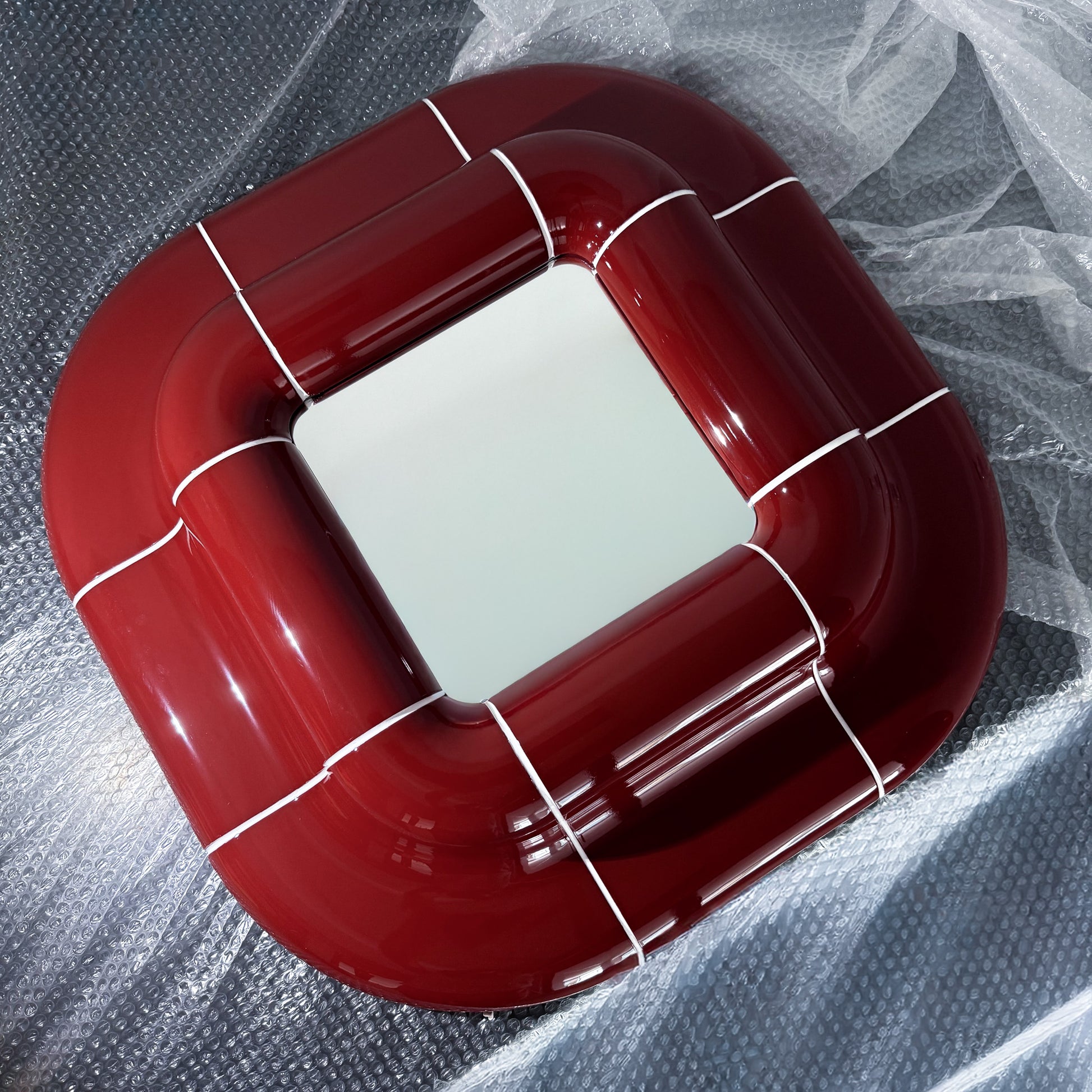 Lolo Mirror in Deep Burgundy, handcrafted modular mirror with glossy finish shown from an angled perspective.