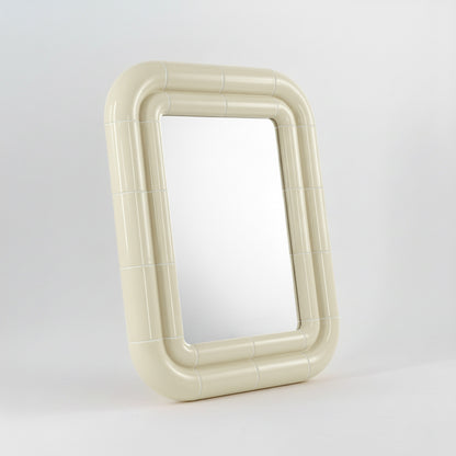 Portalito mirror in Soft Butter, sculptural tubular frame, angled view highlighting depth