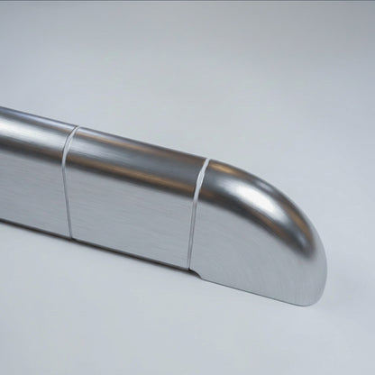 Close-up of the rounded end of the Orbi shelf, polished metallic finish with white grout joints